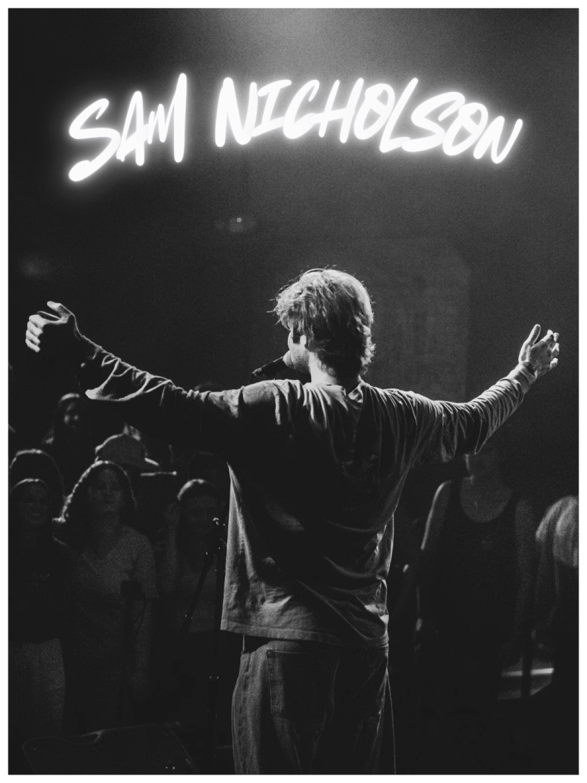 Sam Nicholson poster: singer with arms spread facing the crowd, black and white
